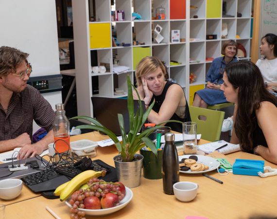 A group of people sitting around a table talking