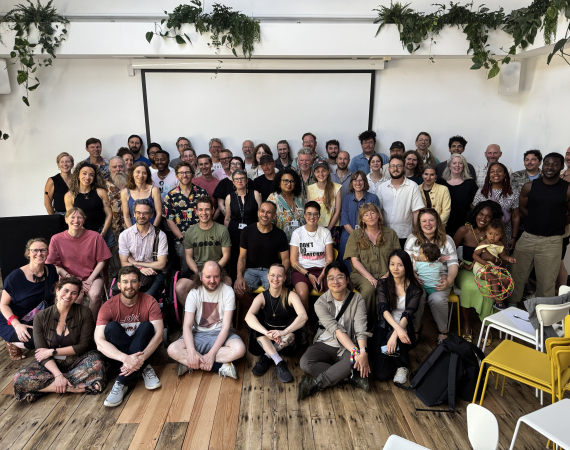 A group of people stand smiling and facing the camera