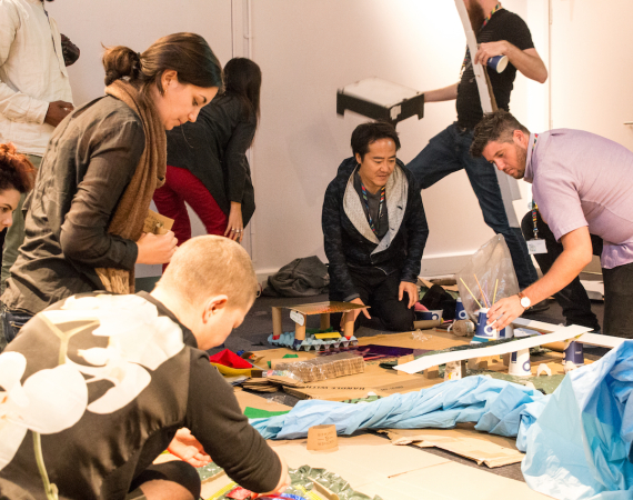 a group of people building a structure with craft materials