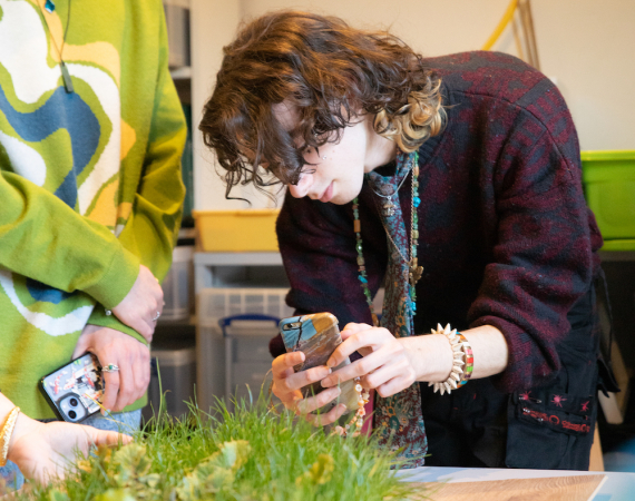 Image of person taking a photograph of grass