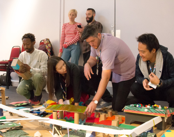 a group of people building a structure with craft materials