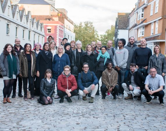 A group of around 20 standing looking at the camera who are the network's Immersion Fellos