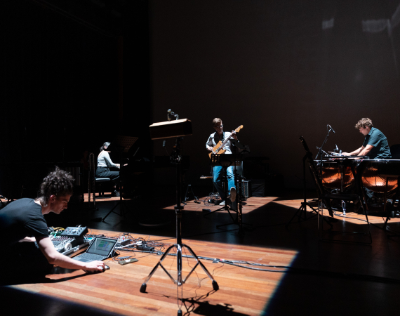 Image of a music ensemble improvising in a theatre space.
