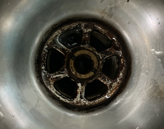 A plughole in a metal sink