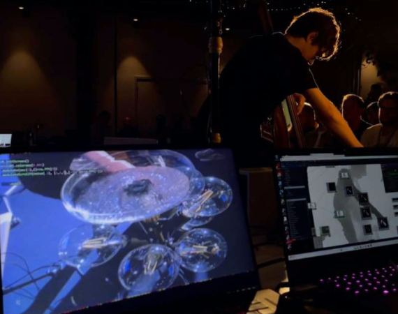 Two screens and a person performing music to an audience