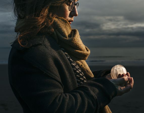 Alison on a beach holding a sea gooseberry