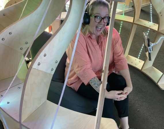 Annie sitting in the joey pod: a timber structure with LED lights.