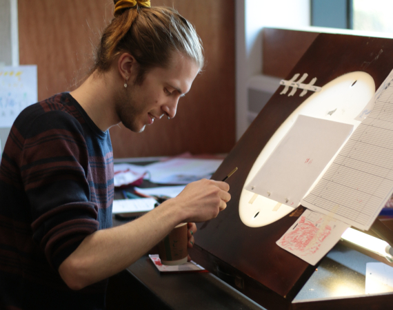 William working over a light table.