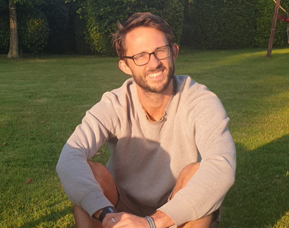 Ben, a white male with glasses, sat in the sun