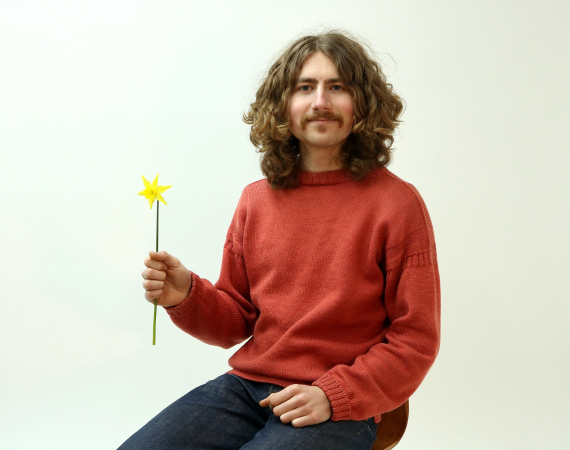 cool dude sitting on chair holding yellow flower