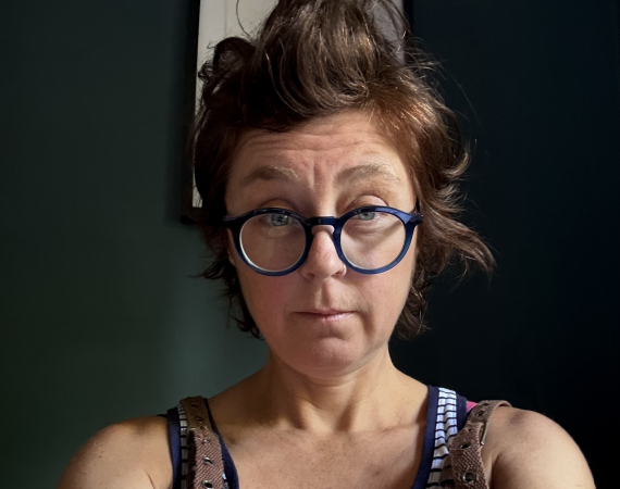 Woman with short brown hair and blue glasses