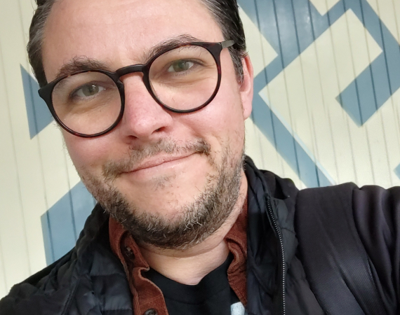 Photo of Matt Gras in front of the Watershed logo