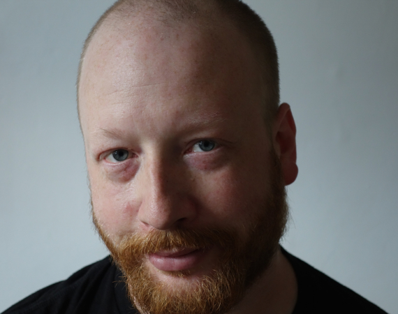 Picture of Tim X Atack, a white man in his 50s with a red beard and bald head