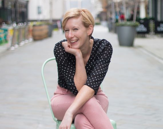 Jo sits in a chair in a Bristol street