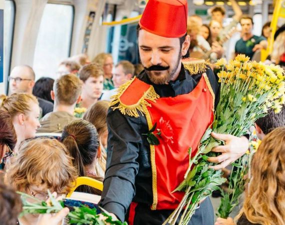 Performing on a train, handing out flowers to festival goers