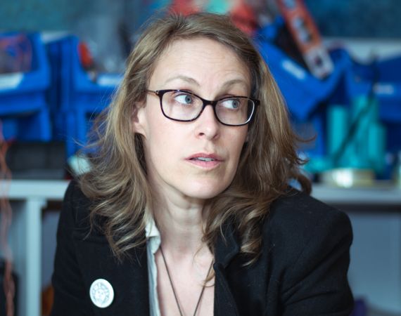 Portrait of a woman with glasses looking up into the corner.