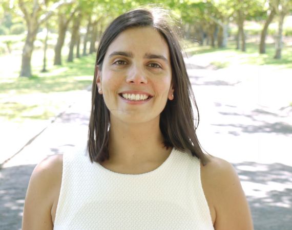 A woman standing in a sunlit park