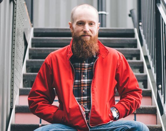 Photo of Luke Emery sitting on a flight of stairs