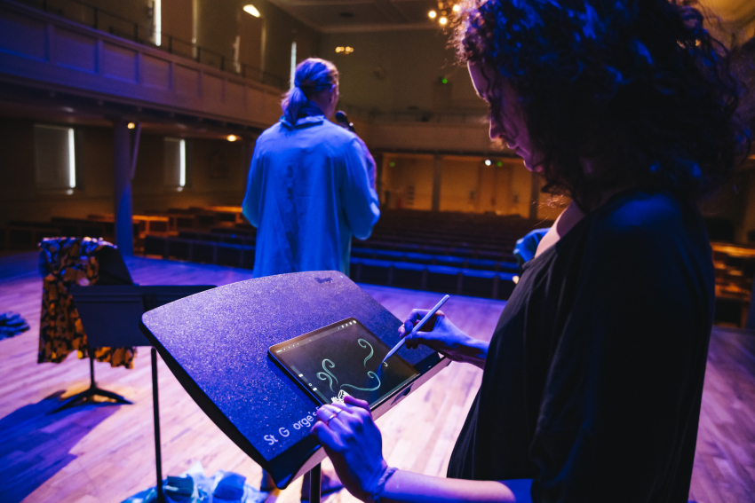 Live illustrator drawing on stage with a performer