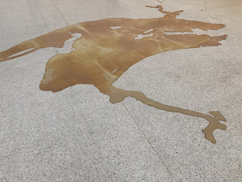 Beige rubber stretched out on a concrete floor in a map-like pattern